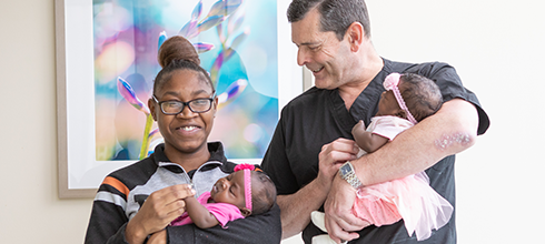A mother and her fetal care specialist hold her twin babies A mother and her fetal care specialist hold her twin babies